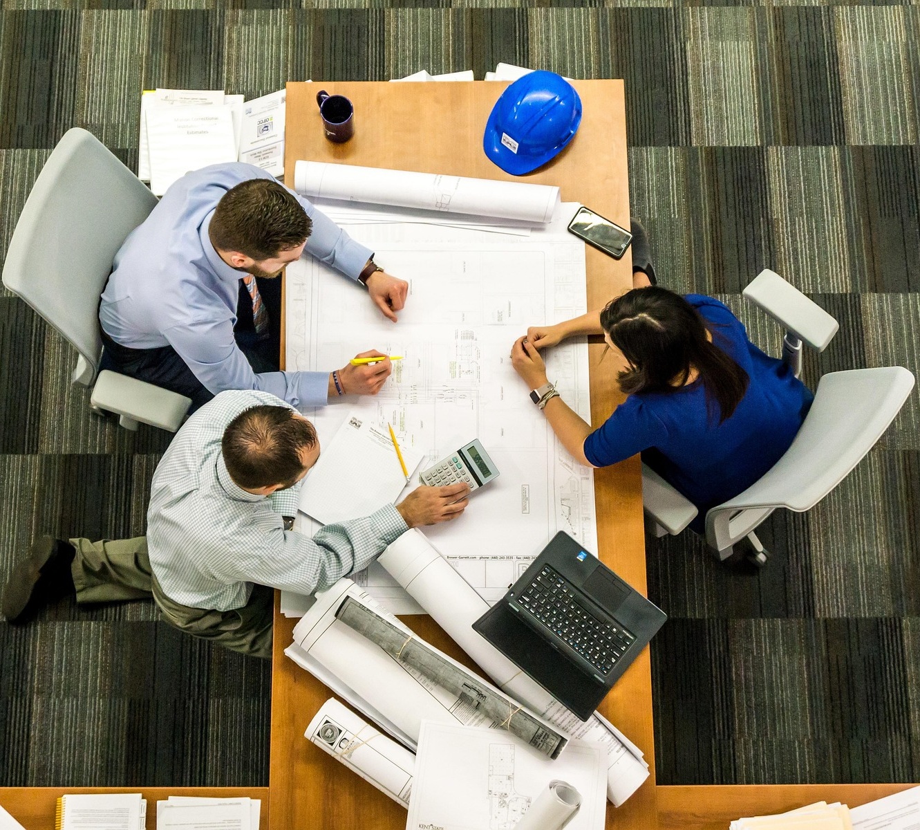 Equipo técnico revisando planos de un proyecto sobre la mesa de trabajo